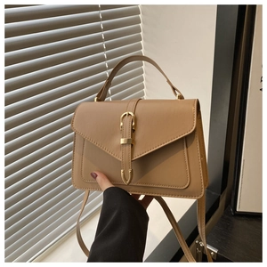 Close-up of khaki envelope handbag with premium golden buckle and textured PU leather