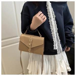 Sac bandoulière en cuir kaki avec fermoir doré élégant et rabat porté par un mannequin
