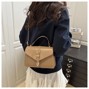 Vue arrière du mannequin portant un sac bandoulière en cuir kaki avec boucle dorée