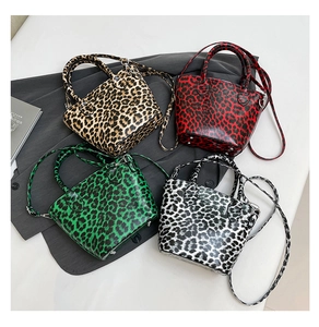 Close-up of four stylish leopard print handbags in red, green, brown, and black patterns