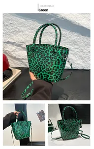 Detail view of the green leopard print bucket bag with dual handles and shoulder strap