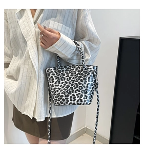Detail of a leopard print handbag with glossy texture and detachable shoulder strap