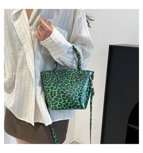 Detail of green leopard print mini bucket bag with top handles and adjustable strap
