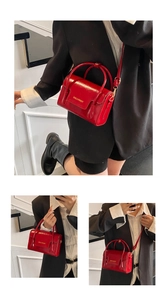 Détail du sac à main rouge en cuir verni avec lettrage doré et bandoulière réglable