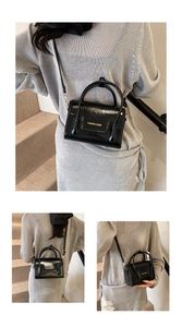 Détails d'un mini sac bandoulière en cuir verni noir avec texte doré et finitions chic