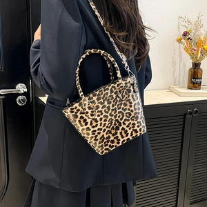 Fashionable leopard print handbag with glossy leather finish and adjustable shoulder strap