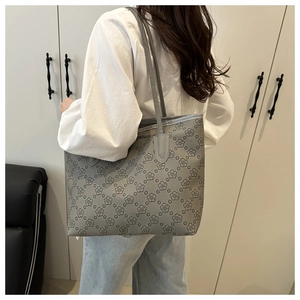 Detail view of a large grey floral tote bag worn over the shoulder with casual outfit