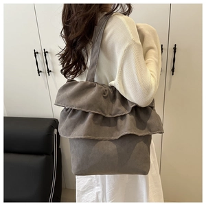 Detail of grey ruffled tote bag with white contrast stitching and large capacity design