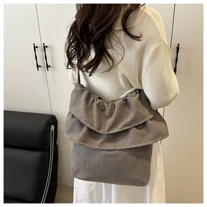 Detail of dark grey tote bag featuring ruffle trim and soft brushed canvas material
