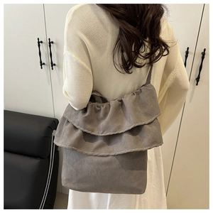 Detail of grey ruffled tote bag in soft brushed fabric with layered frill design