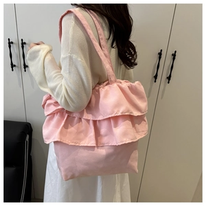 Detail of pink ruffled tote bag featuring layered frill design and soft fabric texture