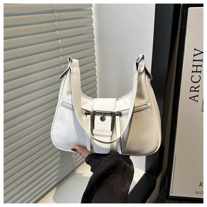 Detail shot of white half-moon shoulder bag with wide leather buckle and side zipper