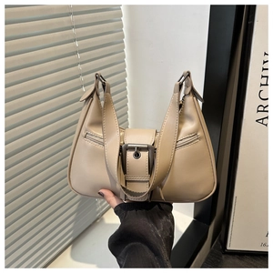 Detail of minimalist beige underarm bag featuring metal buckle and zipper accents