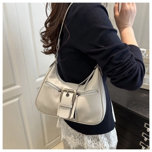 Detail of the retro light grey half-moon bag worn under the arm for a stylish modern look