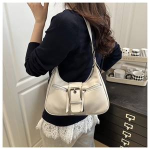 Close-up of cream faux leather underarm bag with vintage buckle and zipper on a model