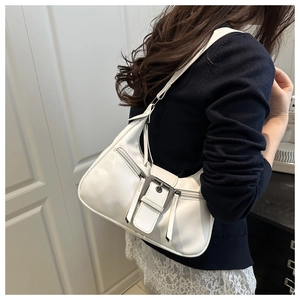 Close-up of white PU leather underarm bag featuring decorative buckle and tassel zippers