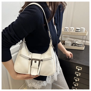Detail of retro cream underarm bag with bronze buckle and matte leather texture