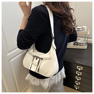 Side view of white faux leather crescent underarm bag with silver metallic buckle detail
