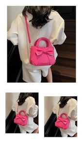 Detailed view of neon pink bow handbag with fashion text and adjustable shoulder strap