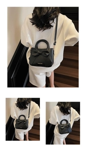 Detail of black crossbody bag with large bow and adjustable strap on a model