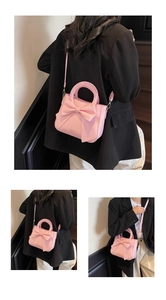 Detail showing pink leather tote with large bow, gold hardware and adjustable strap