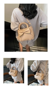 Close-up of stylish beige handbag featuring a large decorative bow and round top handles