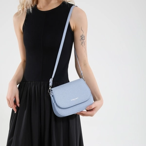 Light blue twill saddle bag with adjustable strap and gold fashion lettering on cover