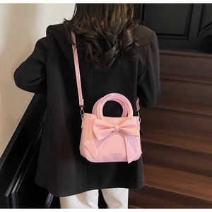Pink bow tote bag detail showing large 3D ribbon and fashion text on faux leather
