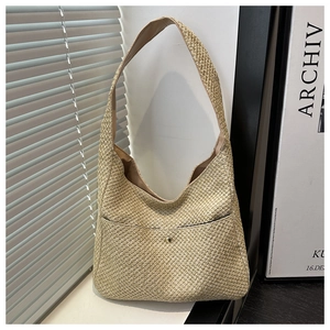 Detailed texture of hand-woven straw hobo bag with elegant golden button and fabric lining