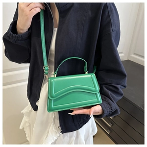 Dettaglio della borsa in pelle verde con patta a onde e rifiniture a doppia cucitura