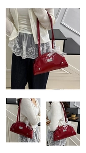 Detail of red patent leather shoulder bag featuring a white lace bow and silver logo