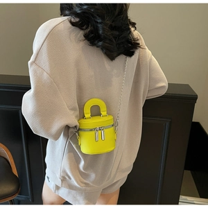 Detailansicht einer gelben Mini-Zylindertasche mit silberner Kette in der Rückansicht