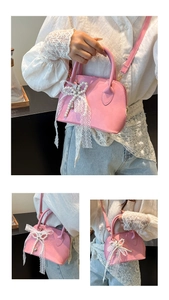 Detail of pink PU leather bowling bag featuring a lace bow and pearl charms accessory