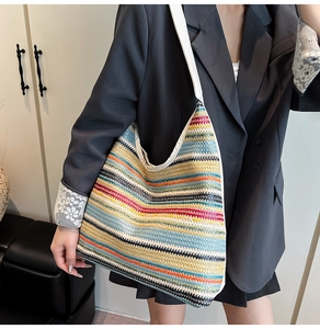 Gros plan d'un grand sac fourre-tout tissé à rayures colorées avec bandoulières blanches