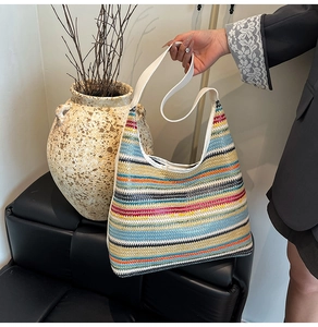 Détail d'un sac cabas tissé à rayures arc-en-ciel avec bandoulière blanche en cuir