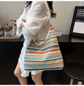 Détail du sac cabas en paille tissée colorée avec rayures vives et large bandoulière