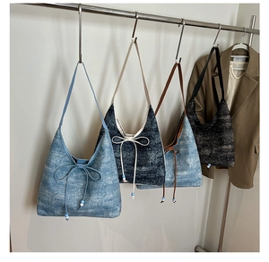 Detail view of denim tote bags with bow and bead accents hanging in a stylish closet