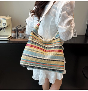 Détail d'un sac cabas tissé à rayures multicolores au motif tricoté bohème