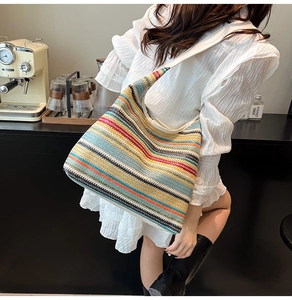 Vue détaillée du sac hobo tissé à rayures colorées assorti à une robe blanche