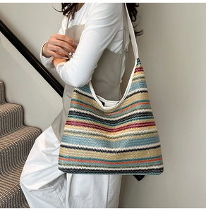 Gros plan du sac cabas tissé à rayures colorées avec bandoulière en toile sur modèle
