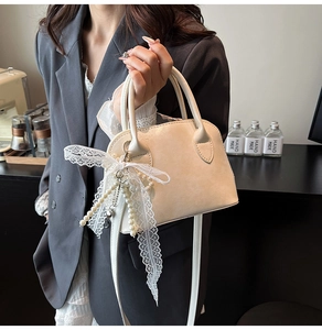 Detail der cremeweißen Bowling-Tasche mit Spitzenschleife, Perlen und Lychee-Textur