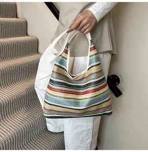 Vue détaillée de la texture tissée colorée et de la bandoulière en cuir du sac cabas