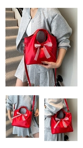 Detail of red faux leather bucket bag with white lace bow and detachable strap