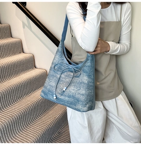 Light blue canvas tote bag featuring a bow decoration and bead details shown on shoulder