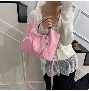 Dettaglio borsa rosa in pelle PU con fiocco in pizzo bianco e tracolla staccabile