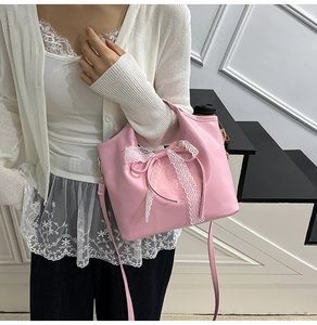 Dettaglio della borsa in pelle PU rosa con bordi in pizzo bianco e un grande fiocco