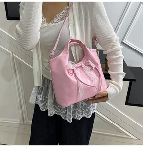Detalle de bolso de mano rosa de estilo dulce con lazo de encaje y correa de hombro