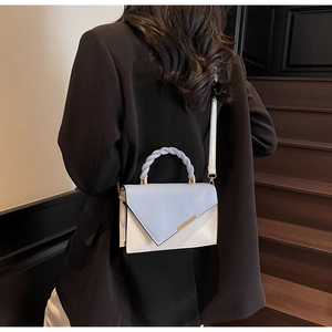 Fashionable blue and beige square bag with gold metallic trim and braided handle detail