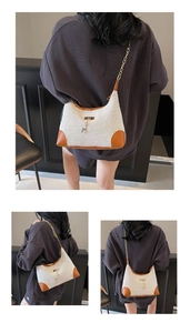 Détail du sac croissant en toile avec bordure en cuir, chaîne dorée et bijou cerf