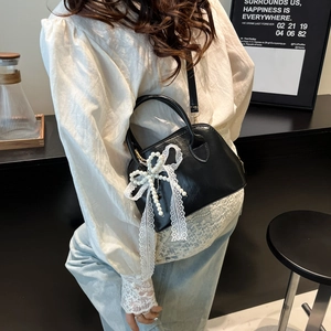 Moderne schwarze Lackleder-Bowlingtasche mit elegantem Perlen-Spitzen-Schleifen-Anhänger
